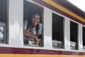 Young asian travel by train sticking her head out of the train, Happy smiling woman female girl looks out from train Royalty Free Stock Photo