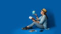 Young asian traveler happy in blue shirt holding passport with holding ball world in the hand. concept travel with equipment for