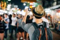 Young Asian traveler taking photo with mobile phone in Khaosan road in Bangkok, Thailand.