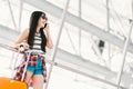 Young Asian traveler woman or college student using mobile phone call at airport with luggage. Study or travel abroad concept