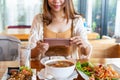 Young Asian traveler woman`s hands using mobile phone take a photo of her lunch before eating in the local restaurant. Close up Royalty Free Stock Photo