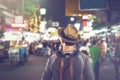 Young Asian traveling backpacker in Khaosan Road night market in Royalty Free Stock Photo