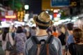 Young Asian traveling backpacker in Khaosan Road night market in evening in Bangkok, Thailand.