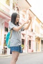 Young Asian traveling blogger or backpacker using route application on the mobile phone to find the needed address in a city. Royalty Free Stock Photo