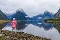 Young Asian traveler girl from back standing at Milford Sound; Fiordland National Park, South Island, New Zealand Royalty Free Stock Photo