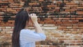 Young Asian traveller girl exploring tourist attractions on holiday and taking photographs