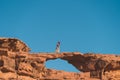 Young Asian traveller walking on natural rock bridge in Wadi Rum desert in Jordan, Arab, Asia Royalty Free Stock Photo