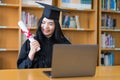 A young Asian university graduate woman in graduation gown expressing joy and excitement to celebrate her education achievement in Royalty Free Stock Photo