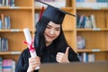 A young Asian university graduate woman in graduation gown expressing joy and excitement to celebrate her education achievement in Royalty Free Stock Photo