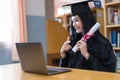 A young Asian university graduate woman in graduation gown expressing joy and excitement to celebrate her education achievement in Royalty Free Stock Photo