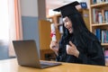 A young Asian university graduate woman in graduation gown expressing joy and excitement to celebrate her education achievement in Royalty Free Stock Photo