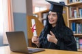 A young Asian university graduate woman in graduation gown expressing joy and excitement to celebrate her education achievement in Royalty Free Stock Photo