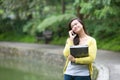 Young asian university student on phone in park Royalty Free Stock Photo