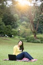 Young asian university student sitting in park. Royalty Free Stock Photo