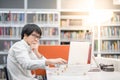 Young Asian man university student working in library Royalty Free Stock Photo