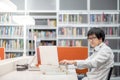 Young Asian university student working in library Royalty Free Stock Photo