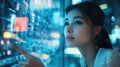 Young Asian Woman Analyzing Data on Transparent Digital Interface in Modern High-Tech Office Environment with City Lights Royalty Free Stock Photo