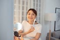 Young Asian woman apply blush on a cheekbone with a brush Royalty Free Stock Photo