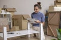 Asian woman is assembling furniture after moving into a new house