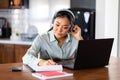 Young Asian woman attending online foreign language classes. Sitting in front of laptop computer with headphones listening course Royalty Free Stock Photo