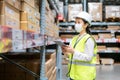 Young asian woman auditor or trainee staff wears mask working during the COVID pandemic in store warehouse shipping industrial.
