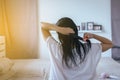 Young asian woman after bath hairbrushing her hair with comb,Female drying long hair with dryer Royalty Free Stock Photo