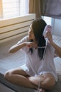 Young asian woman after bath hairbrushing her hair with comb,Female drying her long hair with dryer Royalty Free Stock Photo