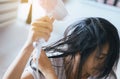 Young asian woman after bath hairbrushing her hair with comb,Female drying her long hair with dryer Royalty Free Stock Photo