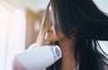 Young asian woman after bath hairbrushing her hair with comb,Female drying her long hair with dryer Royalty Free Stock Photo