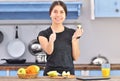 A young asian woman in a black t-shirt makes a fit breakfast and tries to taste a piece of apple