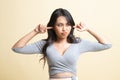 Young Asian woman block both ears with fingers