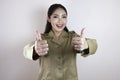 Mladý asijský žena v hnědý hnědožlutý jednotný zobrazené palec nahoru nebo 