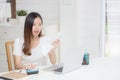 Young asian woman calculating expenses household about finance and frustrated on desk at home. Royalty Free Stock Photo