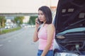 Young Asian woman calling for assistance using mobile phone, after car broke down on the road side Royalty Free Stock Photo