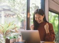 Young Asian woman celebrate success or happy pose with laptop. Royalty Free Stock Photo