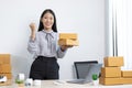 Young Asian woman chatting with a customer on a laptop and displays the product before delivery to confirm the order Royalty Free Stock Photo