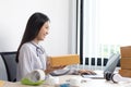 Young Asian woman chatting with a customer on a laptop and displays the product before delivery to confirm the order Royalty Free Stock Photo