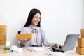 Young Asian woman chatting with a customer on a laptop and displays the product before delivery to confirm the order Royalty Free Stock Photo