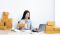 Young Asian woman chatting with a customer on a laptop and displays the product before delivery to confirm the order