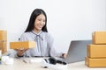 Young Asian woman chatting with a customer on a laptop and displays the product before delivery to confirm the order Royalty Free Stock Photo