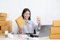 Young Asian woman chatting with a customer on a laptop and displays the product before delivery to confirm the order Royalty Free Stock Photo