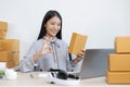 Young Asian woman chatting with a customer on a laptop and displays the product before delivery to confirm the order Royalty Free Stock Photo