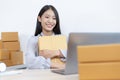 Young Asian woman chatting with a customer on a laptop and displays the product before delivery to confirm the order Royalty Free Stock Photo