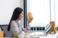 Young Asian woman chatting with a customer on a laptop and displays the product before delivery to confirm the order Royalty Free Stock Photo