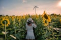 Young asian woman cheerful standing in sunflower field at sunset Royalty Free Stock Photo