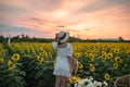 Young asian woman cheerful standing in sunflower field at sunset Royalty Free Stock Photo