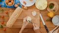 Young Asian woman chef spread butter on rustic rye bread with metal knife on wooden board on kitchen table in house. Fresh Royalty Free Stock Photo