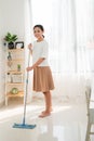 Young Asian woman cleaning floor at home doing chores with attractive smile on face Royalty Free Stock Photo