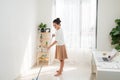 Young Asian woman cleaning floor at home doing chores with attractive smile on face Royalty Free Stock Photo