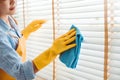 Young asian woman cleaning house wiping dust using Feather broom and duster while cleaning on window House keeping concept